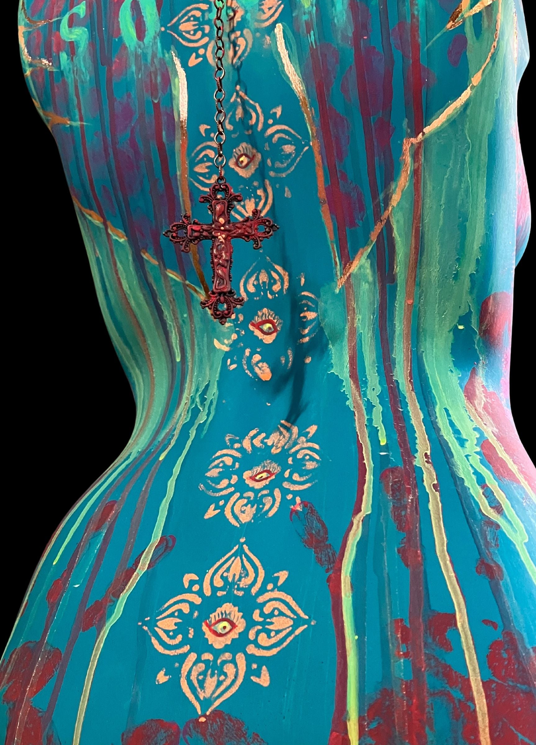 The close up of the back of mixed media mannequin sculpture titled "Break Free", featuring bold turquoise body, rose gold accents, the word ENOUGH, and a turning base by J Elise Art.