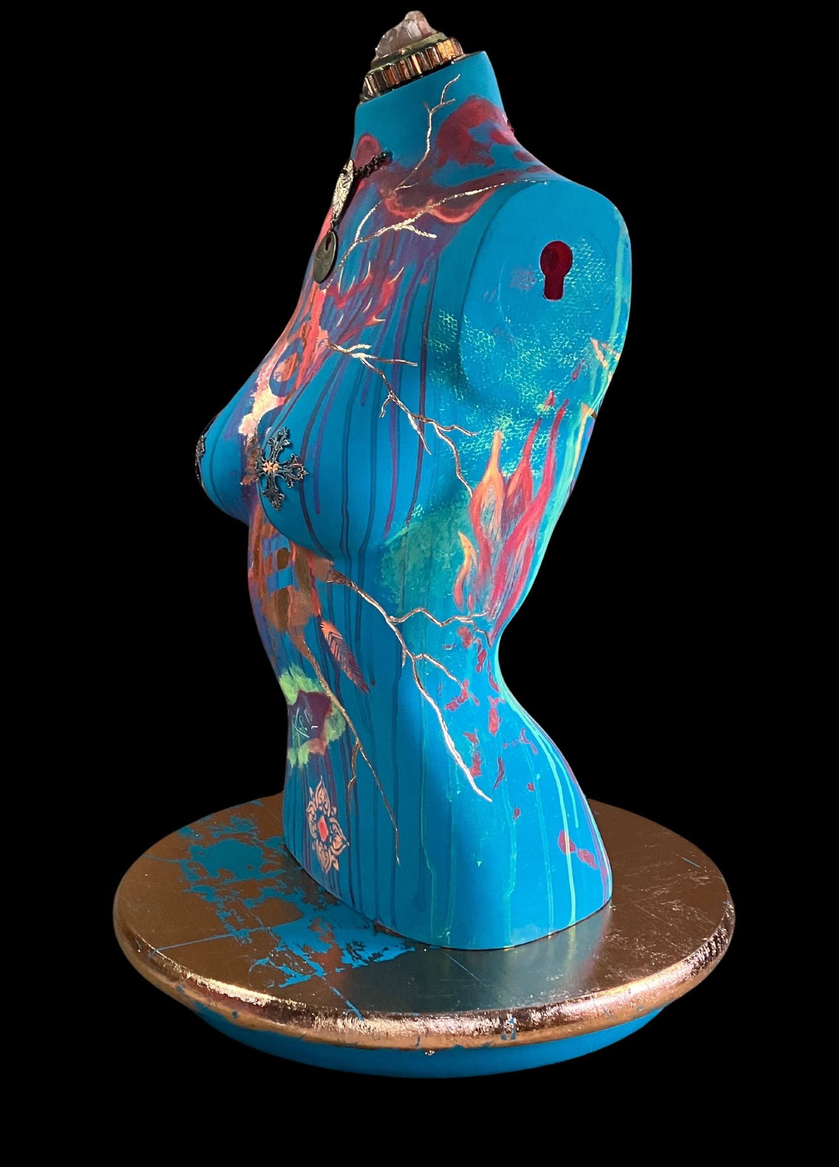 Left side view Mixed media mannequin sculpture titled "Break Free", featuring bold turquoise body, rose gold accents, flames trailing up the side, and a turning base by J Elise Art.