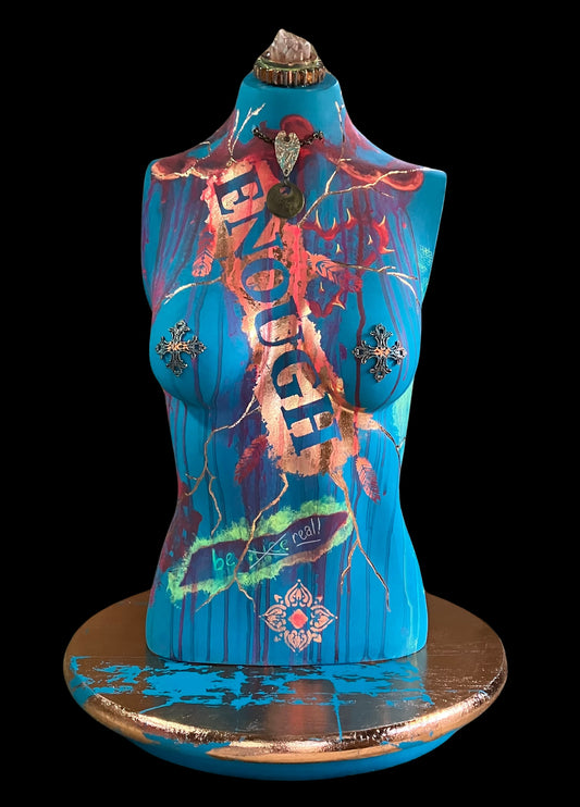 Mixed media mannequin sculpture titled "Break Free", featuring bold turquoise body, rose gold accents, the word ENOUGH, and a turning base by J Elise Art.