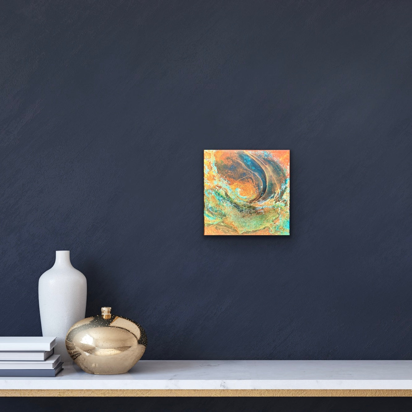 In situ photo of earth-inspired abstract painting with rust, teal, and copper tones, featuring layered organic textures that evoke landscapes, topography, or mineral formations on a dark moody wall in contemporary setting.