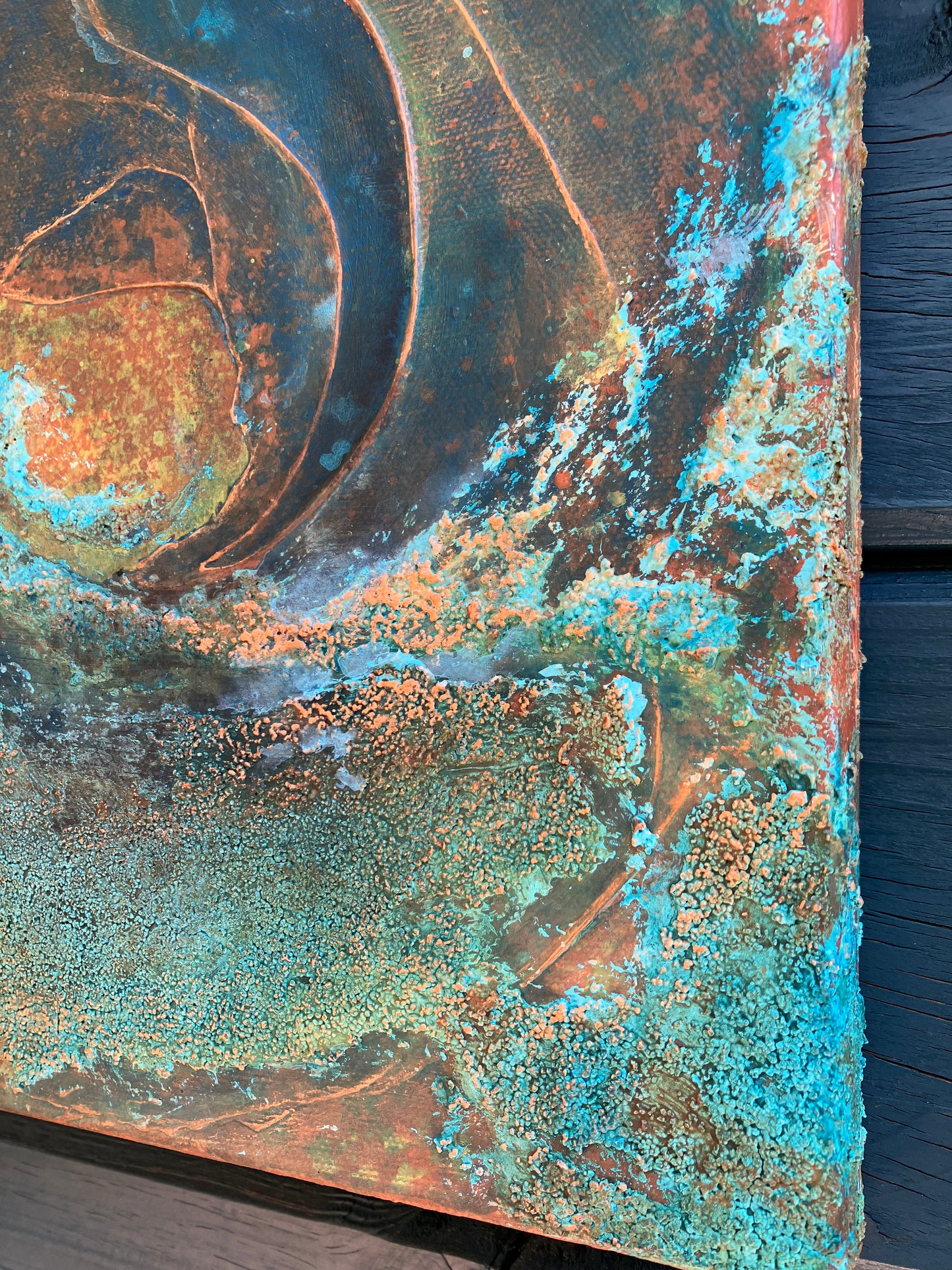Close up showing detail of earth-inspired abstract painting with rust, teal, and copper tones, featuring layered organic textures that evoke landscapes, topography, or mineral formations.